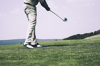 Golfer Swinging Club on Green Course