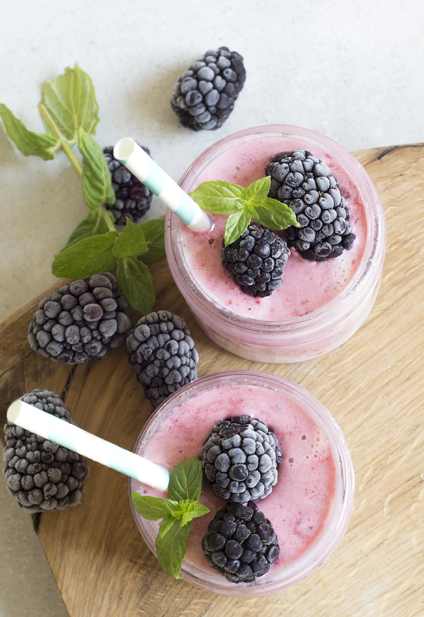 Overhead view of frozen blackberry smoothies in glass jars