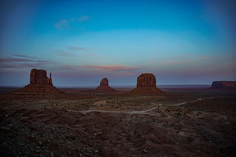 Monument Valley buttes at twilight with winding desert road