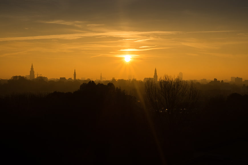 Golden Sunrise Over Silhouetted City Skyline