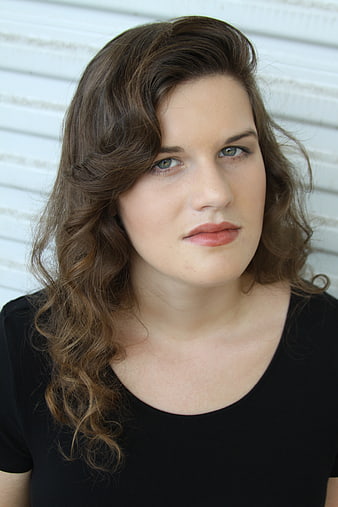 Portrait of a woman with wavy brown hair and blue eyes