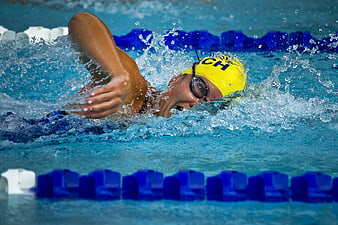 Swimmer in Yellow Cap Performing Freestyle Stroke in Pool