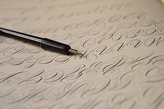 Close-up of fountain pen nib on calligraphy practice sheet